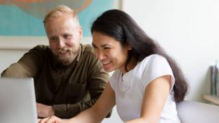 Nainen ja mies katsovat läppäriä.